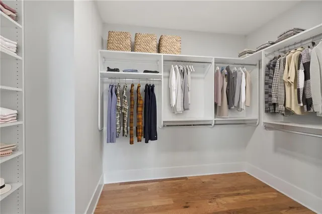 a view of walk in closet with clothes and shoes