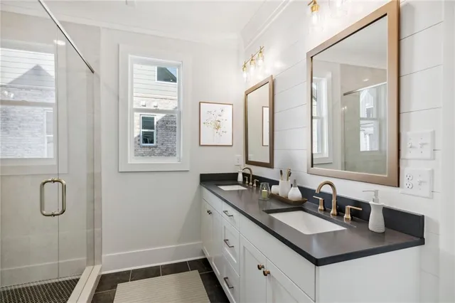 a bathroom with double vanity sinks a mirror and a shower