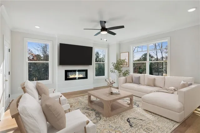 a living room with furniture a flat screen tv and a large window