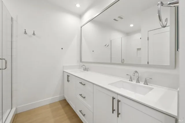 a bathroom with double vanity sink and mirror