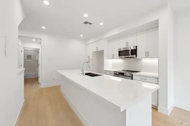 a kitchen with stainless steel appliances a sink stove and refrigerator