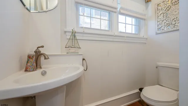 a bathroom with a sink a toilet and a window