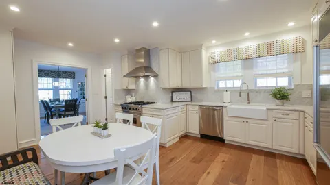 a large kitchen with kitchen island a sink a stove a dining table and chairs