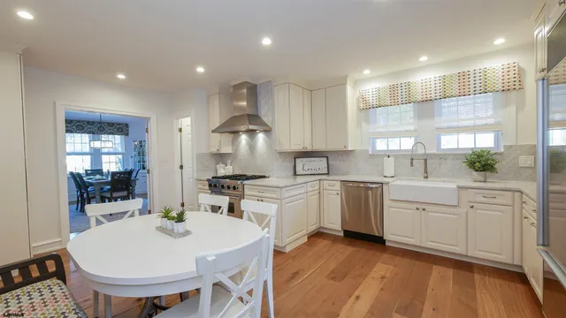 a large kitchen with kitchen island a sink a stove a dining table and chairs