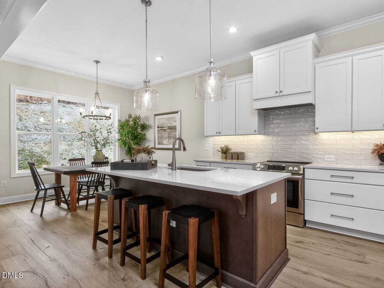 6044 Scalybark Road Durham, NC 27712 - Photo 15 of 39 a kitchen with kitchen island granite countertop a sink a stove a dining table and chairs