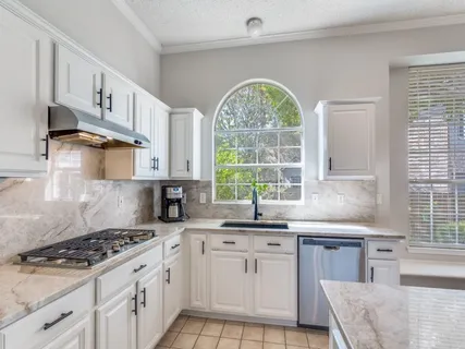 a kitchen with stainless steel appliances a sink a stove a counter space and a window