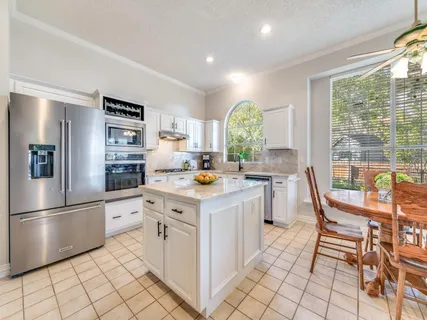 a kitchen with granite countertop a sink appliances and cabinets