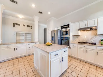 a kitchen with granite countertop a stove top oven sink and cabinets