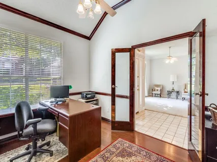 a view of a workspace with furniture and a window