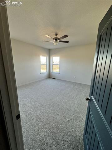 3955 Yoder Road Yoder, CO 80864 - Photo 22 of 27 Unfurnished room with a textured ceiling, carpet floors, and ceiling fan