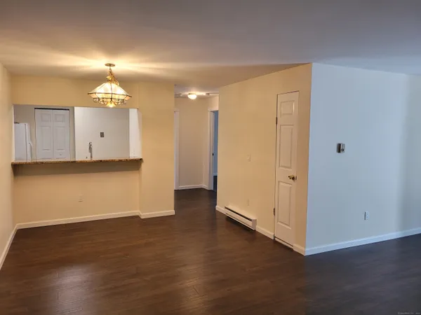 a view of a room with wooden floor and chandelier