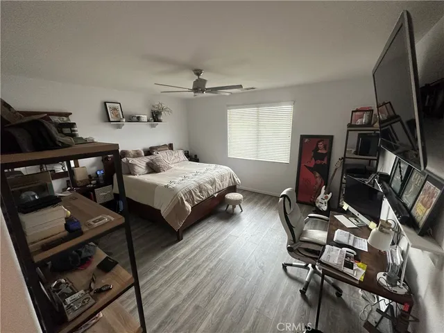 a bedroom with bed and a flat tv screen on the dresser