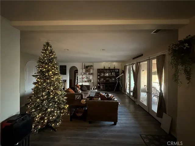 a living room with furniture large window and wooden floor