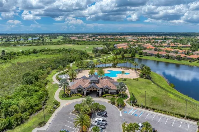 an aerial view of a residential houses with outdoor space and trees