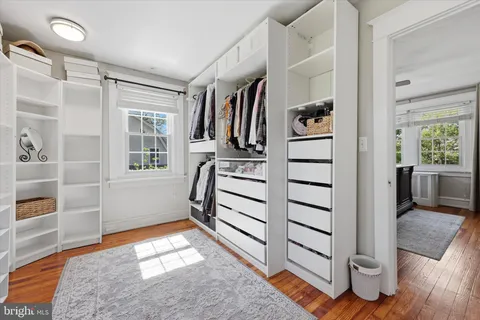 a view of walk in closet with clothes and shoes
