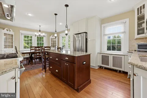 a kitchen with stainless steel appliances granite countertop sink stove and wooden floor