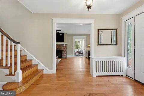 a view of a hallway with entryway wooden floor and windows