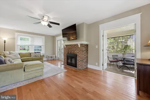 a living room with furniture a fireplace a flat screen tv and a large window