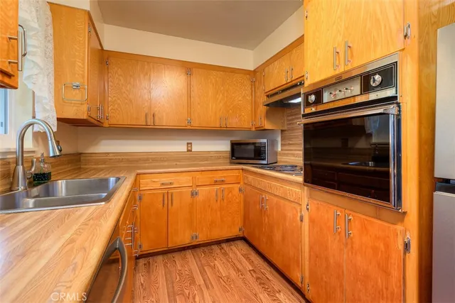 a kitchen with stainless steel appliances granite countertop a sink a stove and cabinets