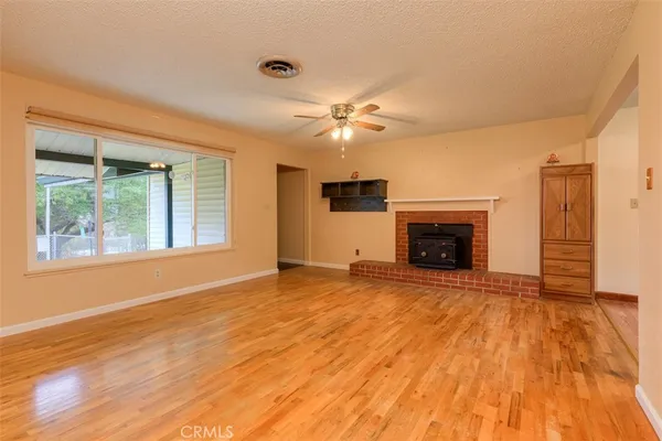 a view of empty room with a fireplace and wooden floor
