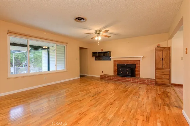 a view of empty room with a fireplace and wooden floor