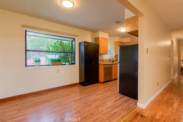 a view of kitchen with stainless steel appliances wooden floor and a window