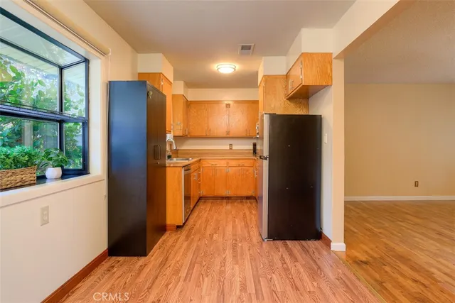 a view of a kitchen with a refrigerator and wooden floor