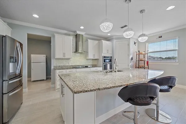 a kitchen with stainless steel appliances granite countertop a sink a refrigerator and a refrigerator