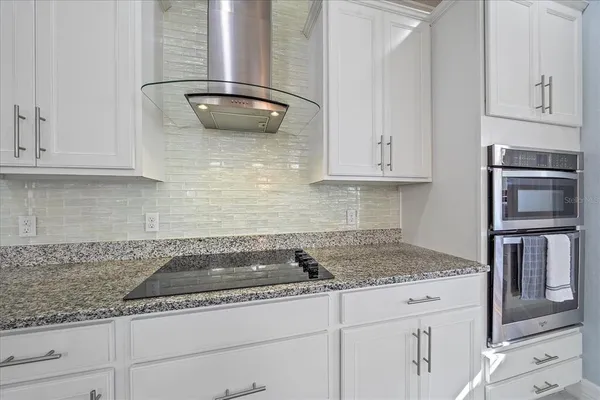 a kitchen with granite countertop a sink and cabinets
