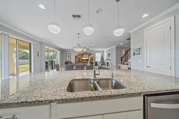a kitchen with stainless steel appliances granite countertop a sink a stove and a large window