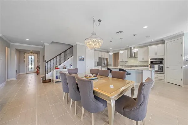 a view of a dining room and livingroom with furniture wooden floor a chandelier