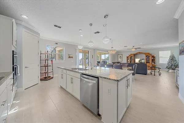 a large white kitchen with a lot of counter space and a sink