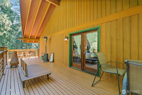 a view of a balcony with chairs and wooden floor