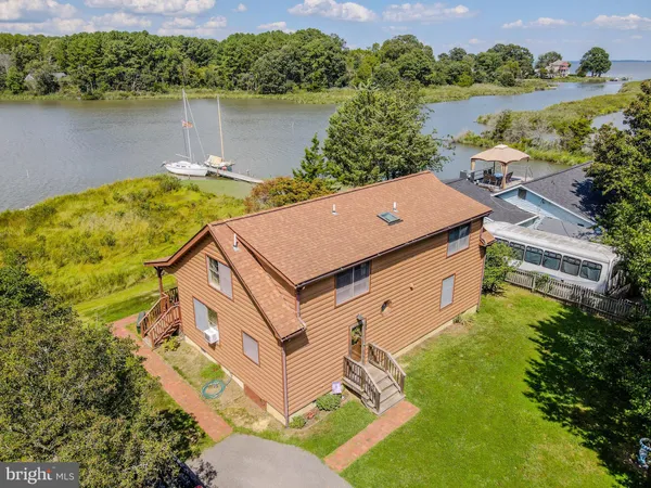 an aerial view of a house with a yard and lake view