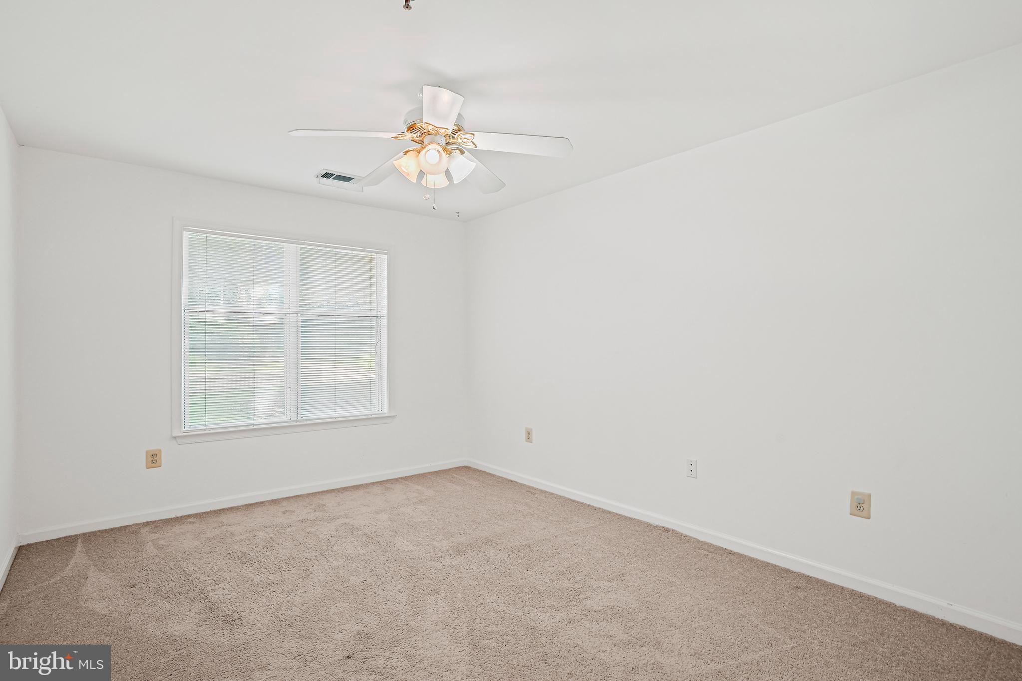 5565 Seminary Road, Unit 113 Falls Church, VA 22041 - Photo 14 of 19 an empty room with a chandelier fan and windows