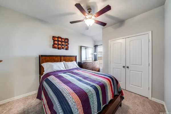 a bed room with a bed and a ceiling fan
