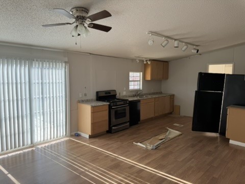 3035 County Road 255 Georgetown, TX 78633 - Photo 18 of 23 Kitchen with black appliances, a textured ceiling, dark wood finished floors, light countertops, and a ceiling fan