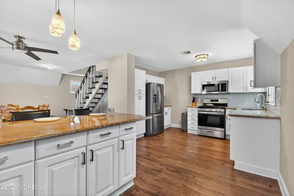 a kitchen with stainless steel appliances granite countertop a refrigerator stove and sink