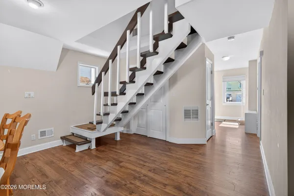 a dining room with furniture entryway and wooden floor