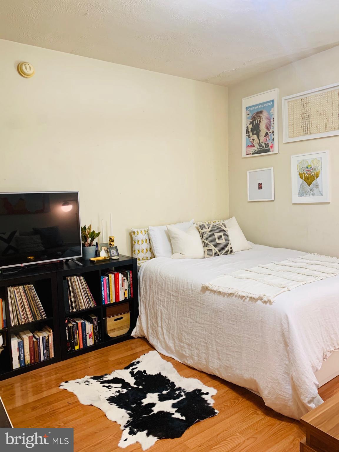1324 Locust Street, Unit 317 Philadelphia, PA 19107 - Photo 3 of 12 a bedroom with a bed and a bookshelf