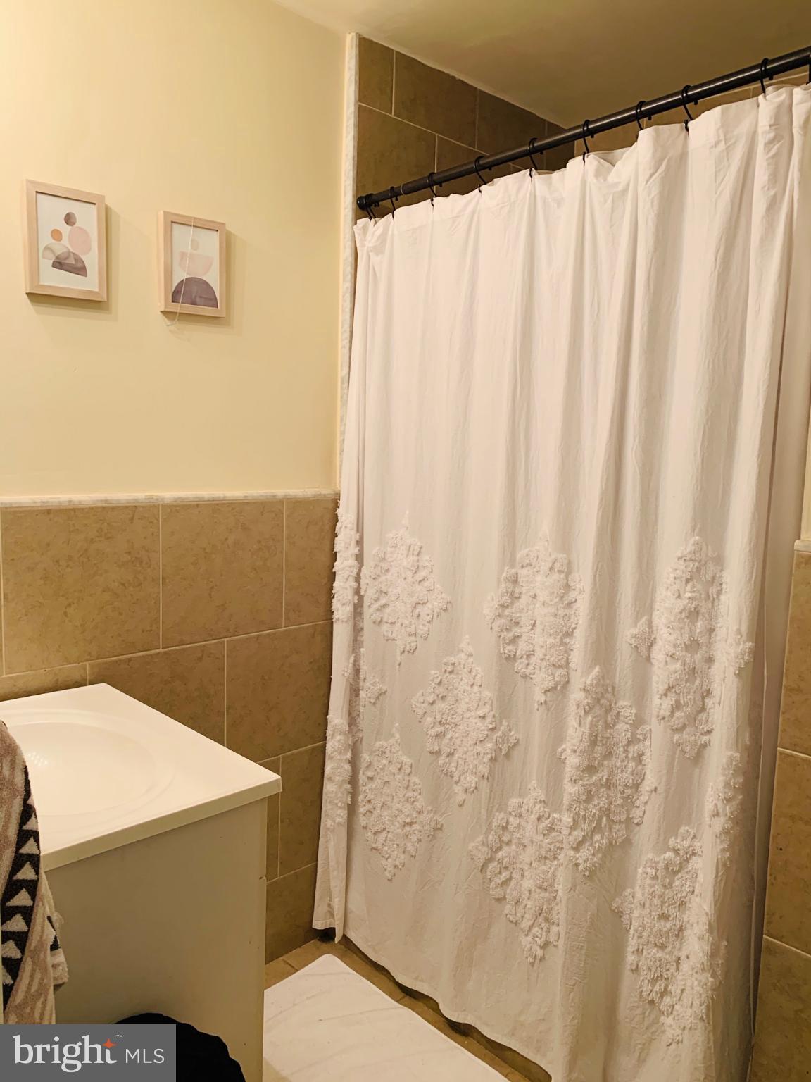 1324 Locust Street, Unit 317 Philadelphia, PA 19107 - Photo 4 of 12 a bathroom with a shower curtain and curtain