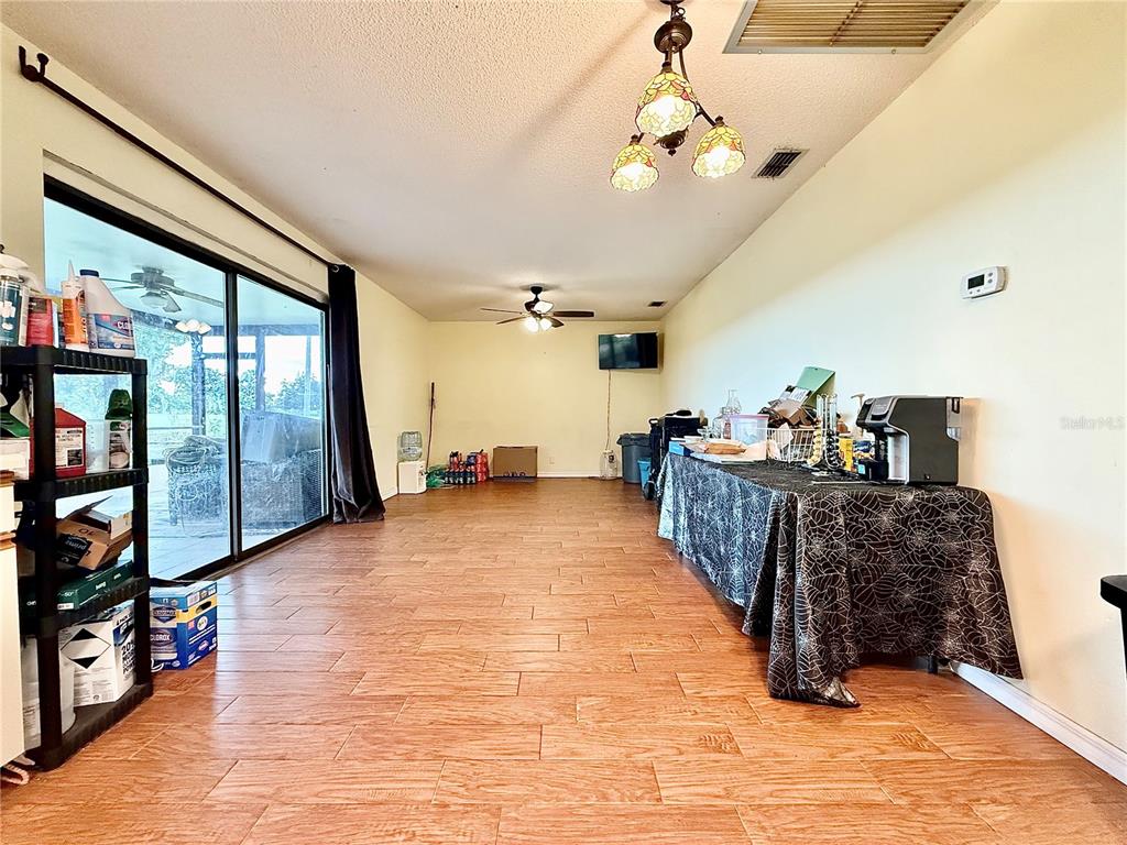 2500 Brook Road North Fort Meade, FL 33841 - Photo 47 of 65 a living room with furniture a flat screen tv and a chandelier