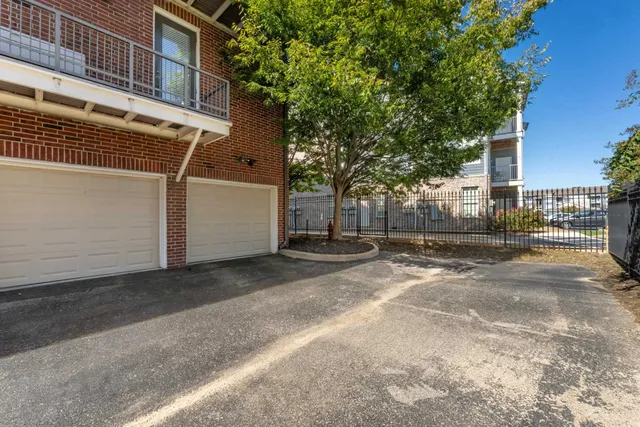 a view of a white house with a yard and large tree