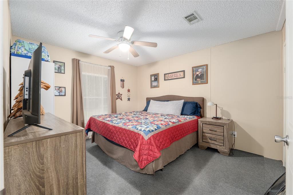 760 Southwest Barney Street High Springs, FL 32643 - Photo 27 of 57 a bedroom with a bed and a chandelier