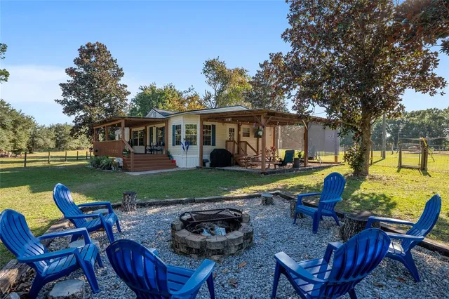 a view of a house with pool and chairs