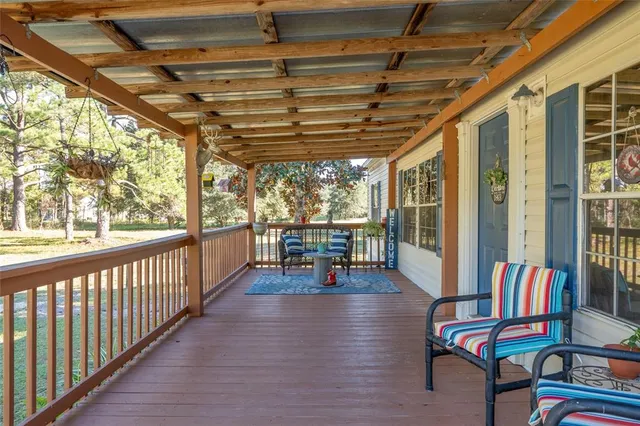 a view of a room with wooden floor furniture and floor to ceiling window