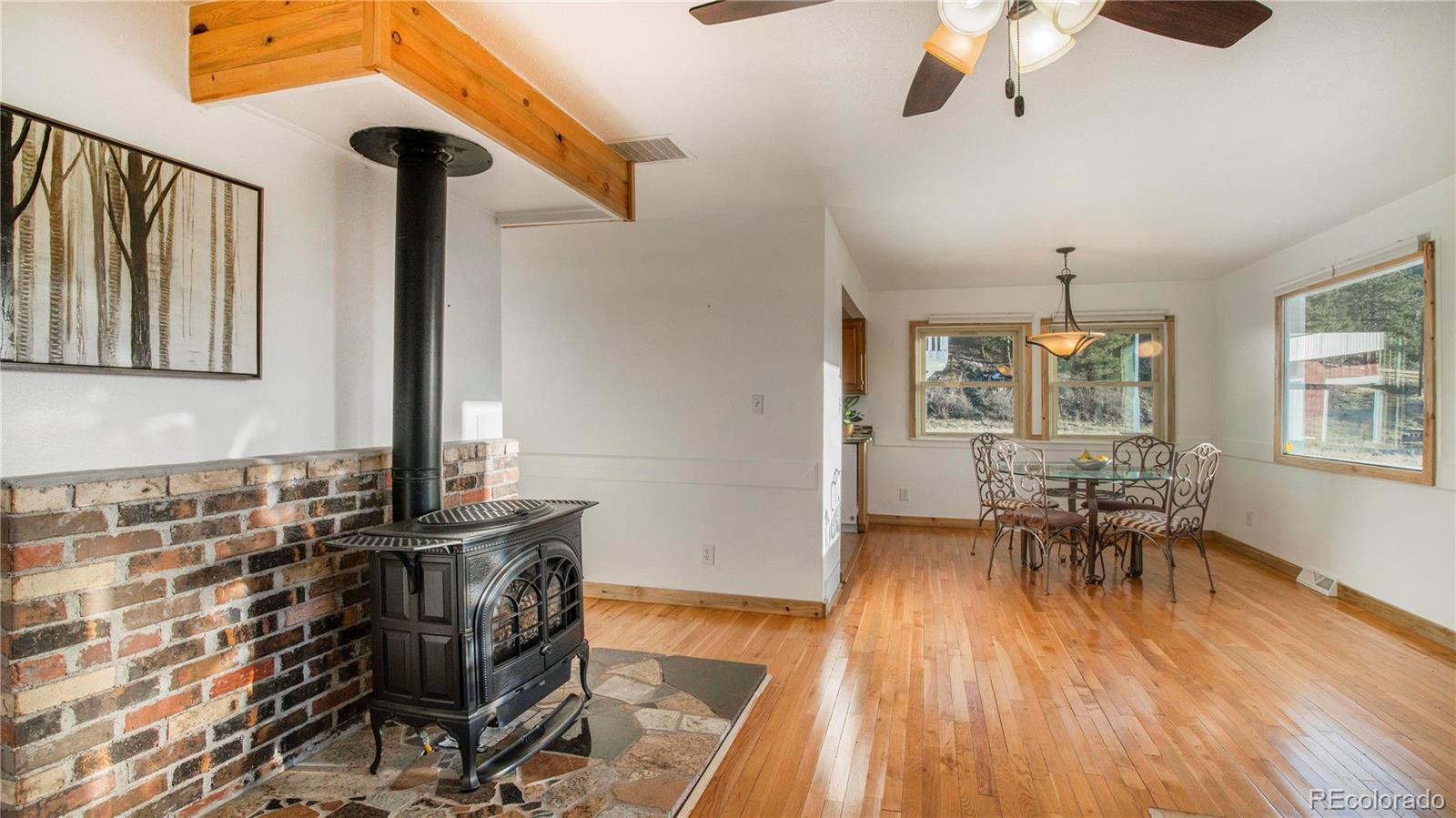 278 Jess-Mar Drive Shawnee, CO 80475 - Photo 7 of 40 a dining room with wooden floor a chandelier a wooden table and chairs