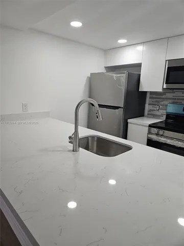 a kitchen with stainless steel appliances a refrigerator sink and microwave