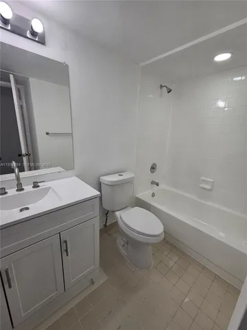 a bathroom with a toilet a sink a mirror and a bathtub