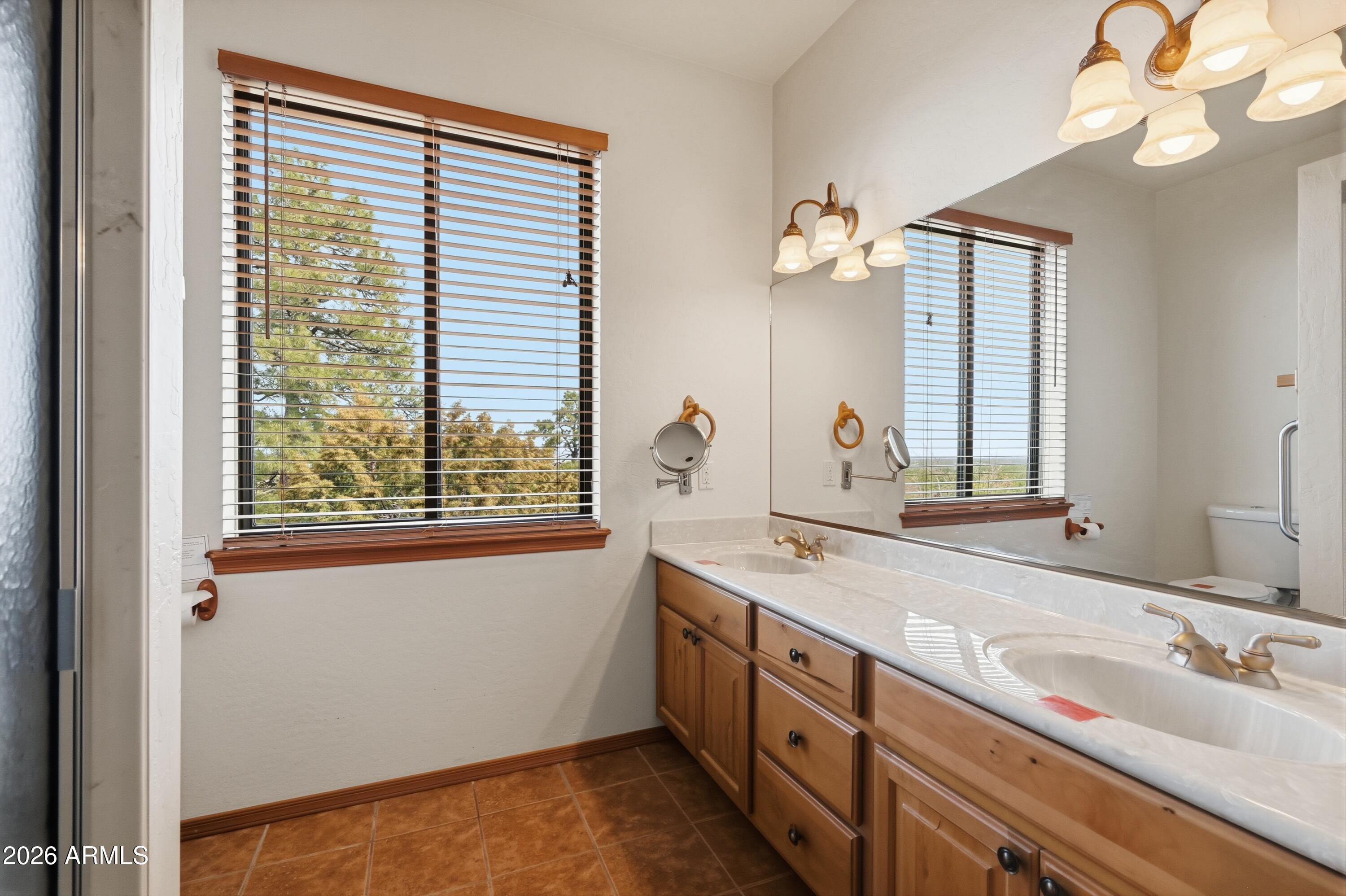 1561 South Canyon Ridge Trail Show Low, AZ 85901 - Photo 25 of 61 a bathroom with a double vanity sink and a window